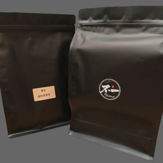Two black coffee bags with labels on a wooden surface