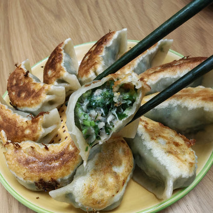 Gyoza dumplings on a plate with chopsticks, on a wooden table