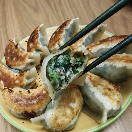 Gyoza dumplings on a plate with chopsticks, on a wooden table