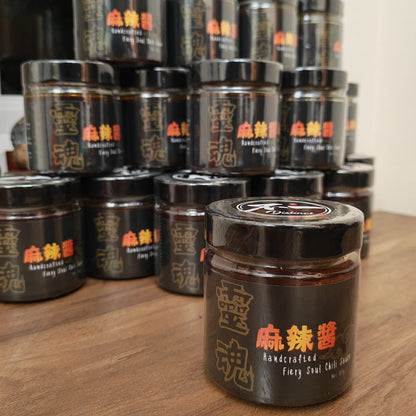Collection of black jars with Chinese text on a wooden surface